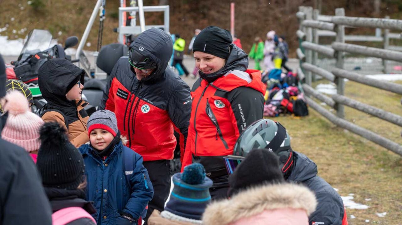 Kinder stehen rund um zwei erwachsene Personen der Bergrettung | © Albert Reiter