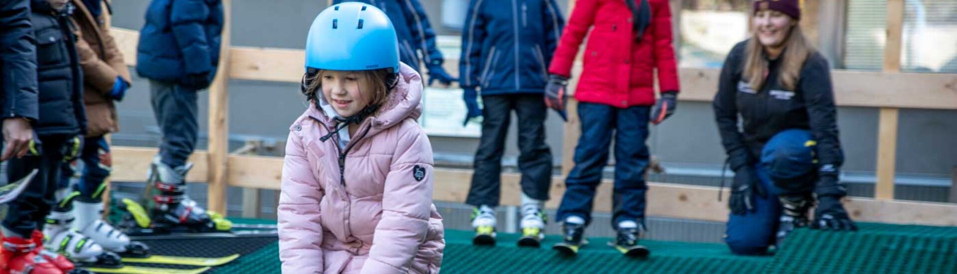 Kind fährt auf Skiern kleine Rampe auf Kunststoff-Piste hinunter | © Albert Reiter