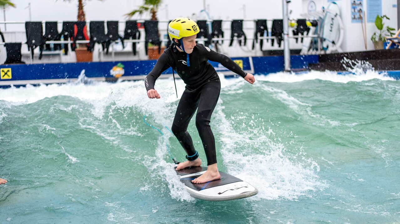 Junge surft auf Welle | © Albert Reiter