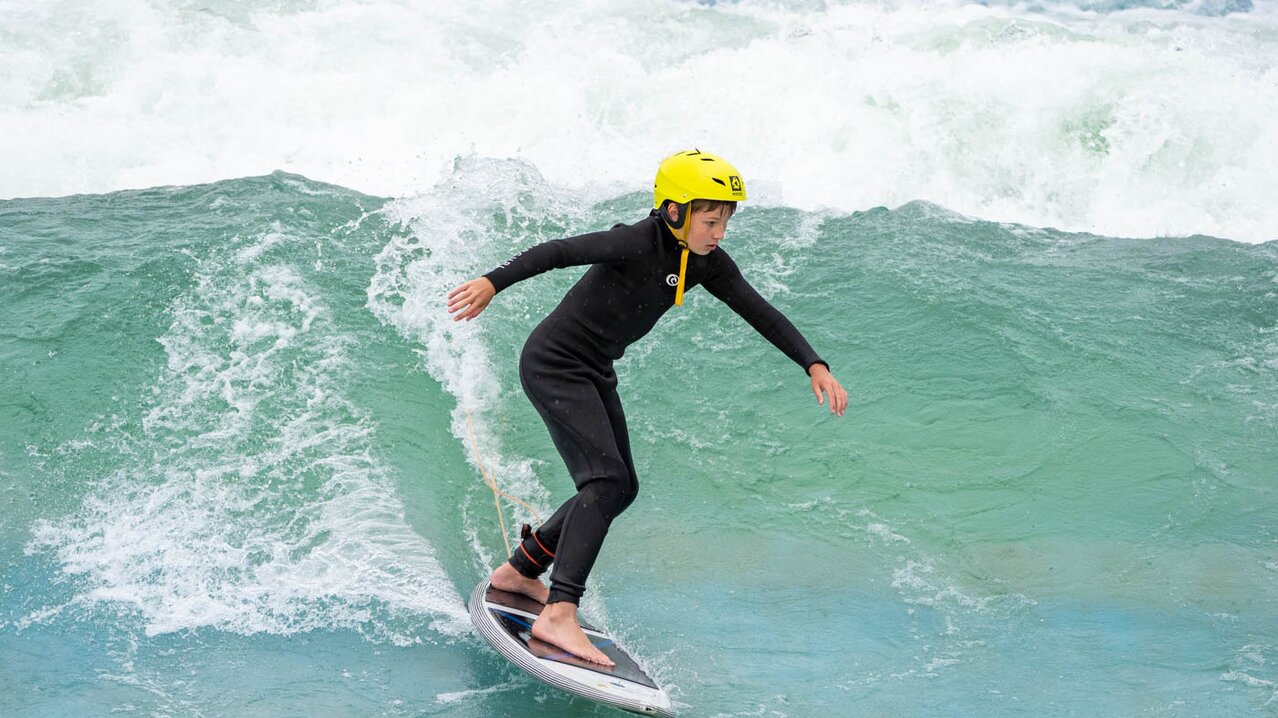 Junge surft auf Welle | © Albert Reiter