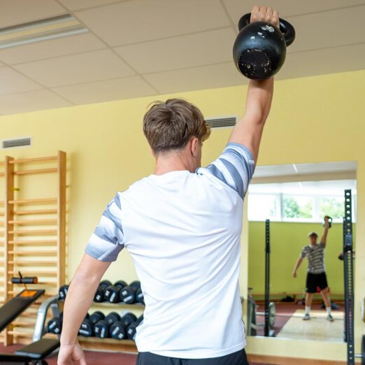 Athlet beim einarmigen Stemmen eines Dumbbells | © Albert Reiter