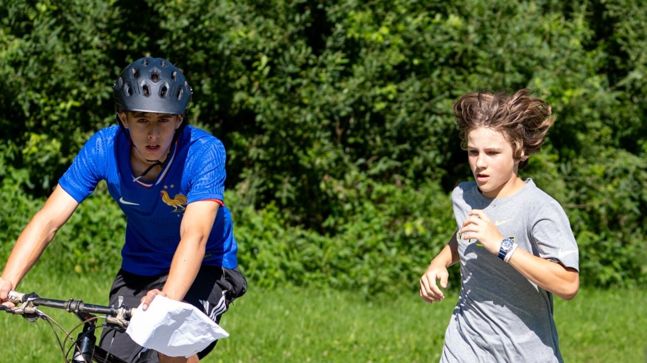2 Jungs beim Orientierungslauf, einer laufend, einer auf dem Fahrrad | © Albert Reiter