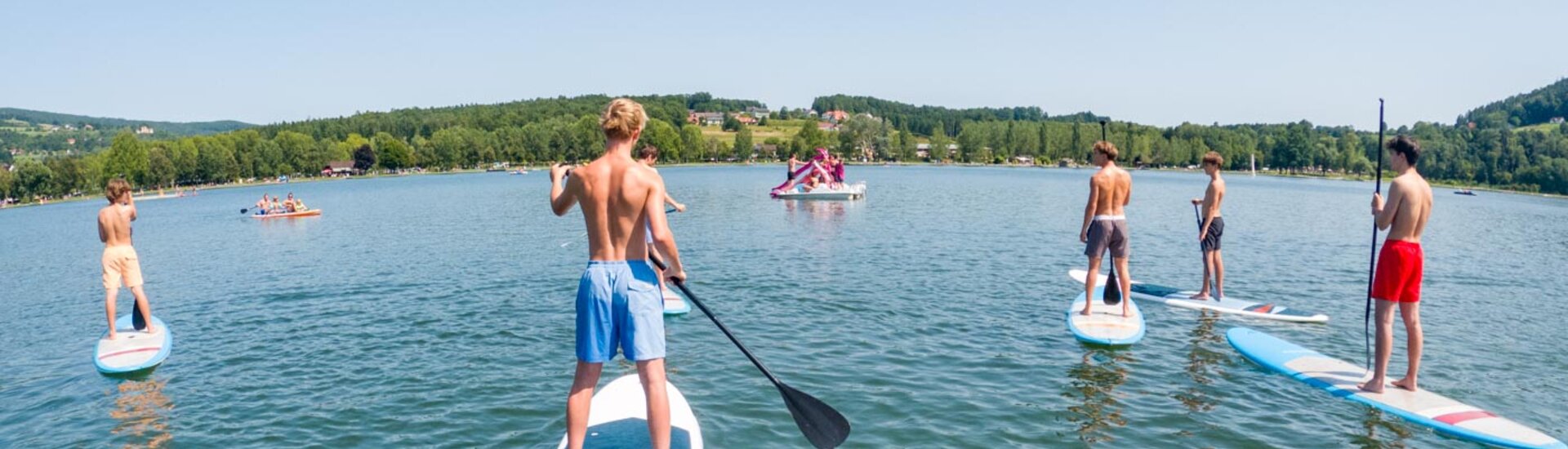 Gruppe Jugendlicher beim SUP fahren an See | © Albert Reiter
