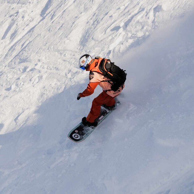 Snowboarderin bei Abfahrt im freien Gelände | © Timon Bachmann